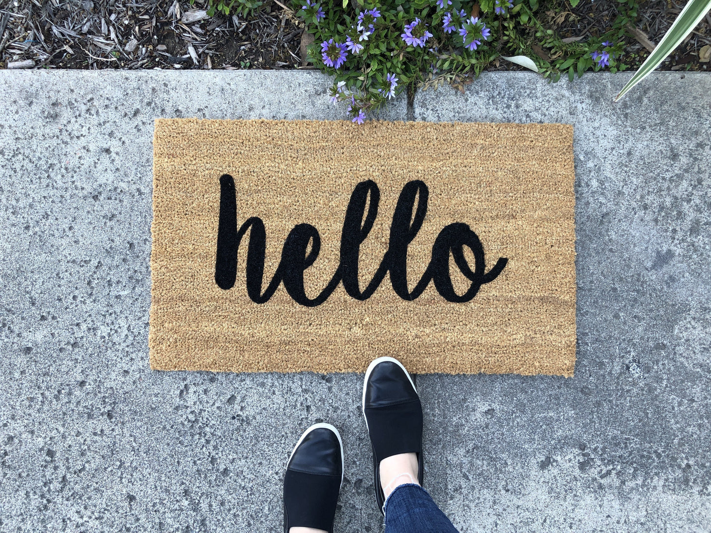 Doormat with 'hello' text on a concrete surface