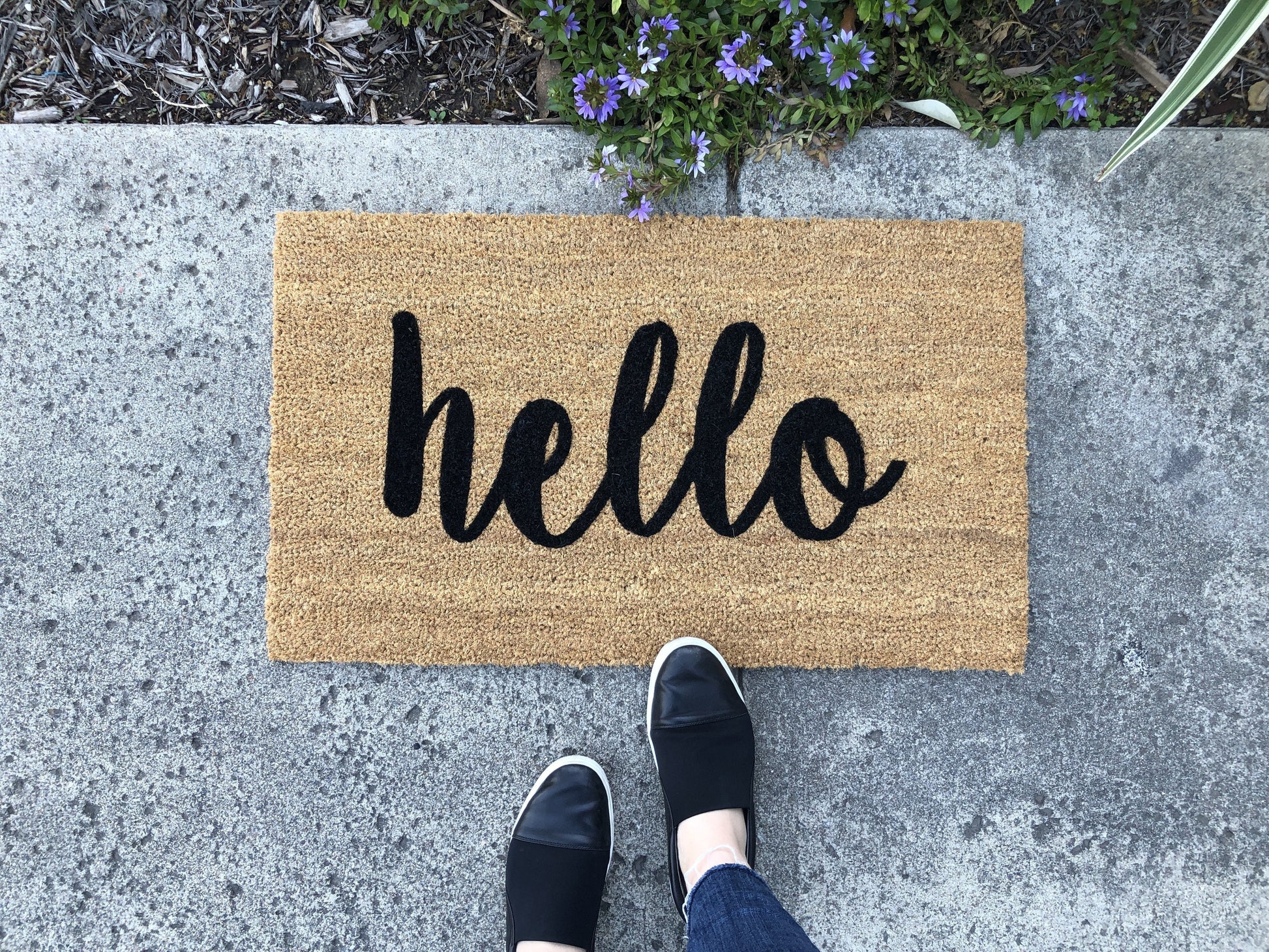 Doormat with 'hello' text on a concrete surface
