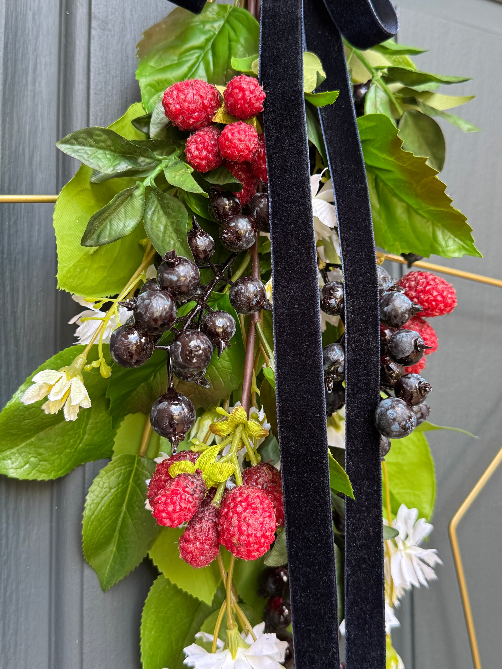 Decorative star wreath with berries and greenery on a wooden surface