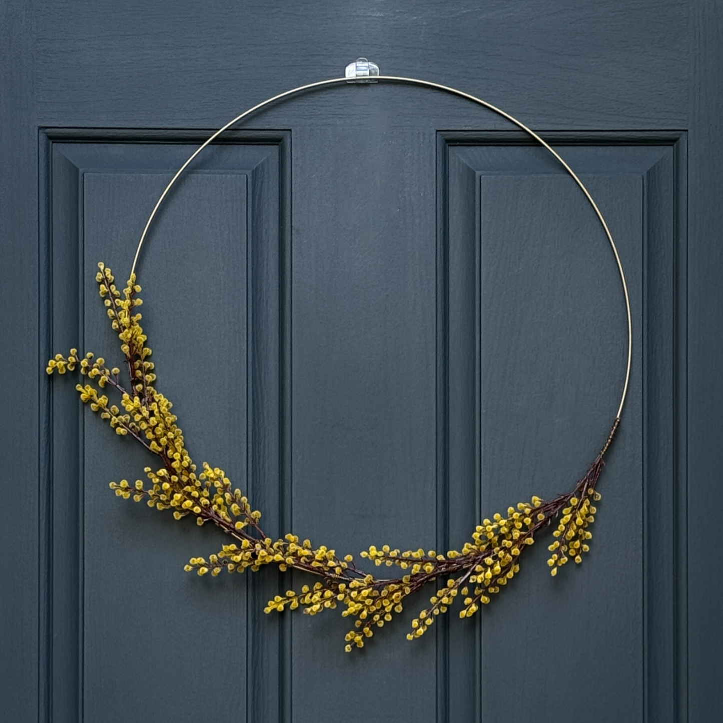 Gold wreath with yellow berries on a blue door