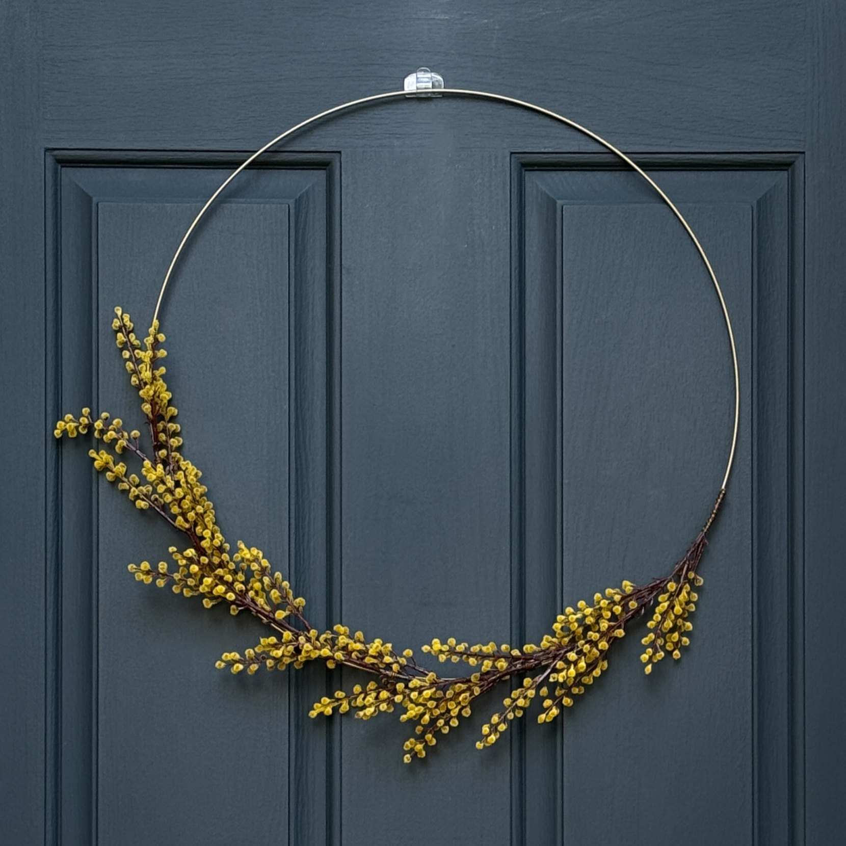 Gold wreath with yellow berries on a blue door