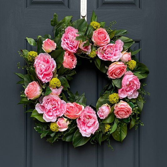 24" Spring Wreath. This high-end, artificial wreath has been handcrafted on a grapevine base and is filled with peonies and roses, and accented with lime green snowball sprays. Florals are nestled in various greenery, including magnolia leaves, shikibu sprays, and button leaf sprays.