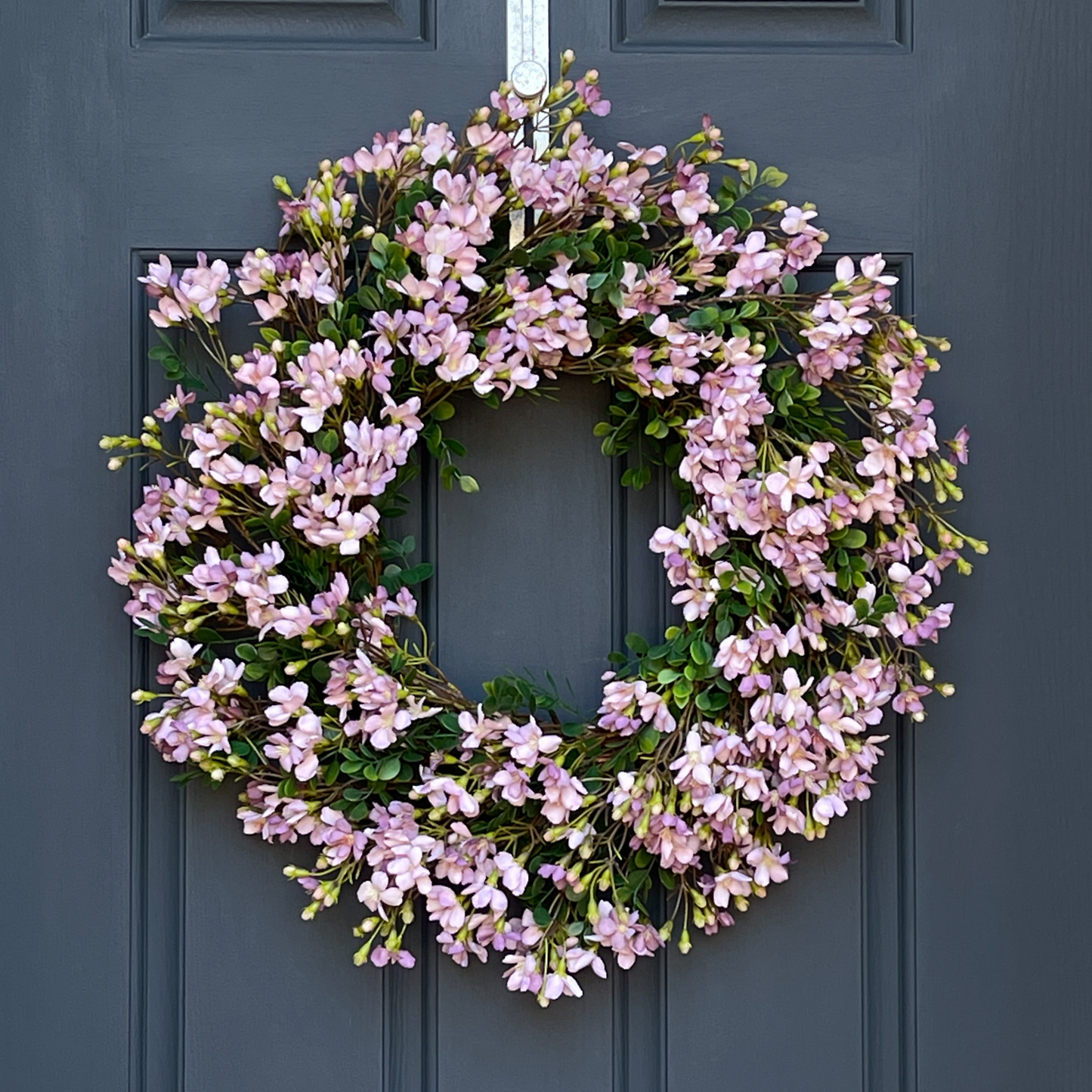 24" spring front door wreath with lavender blossoms and green leaves.