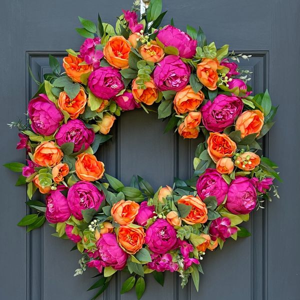 Floral wreath with pink and orange flowers on a blue door
